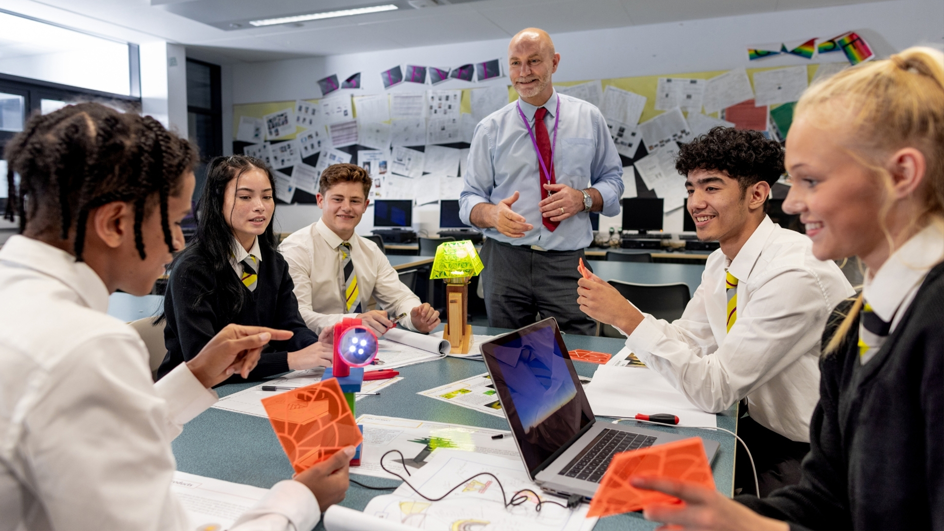 Middle aged male teacher teaching classroom of science students